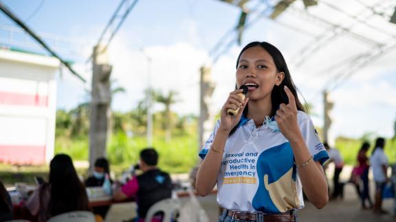 Youth Volunteer Charlaine Mae Leones speaks during a post-Typhoon Opong reproductive health medical mission at a damaged covered court in Masbate province,