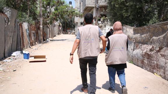 A man and a woman walk down an empty street in Gaza