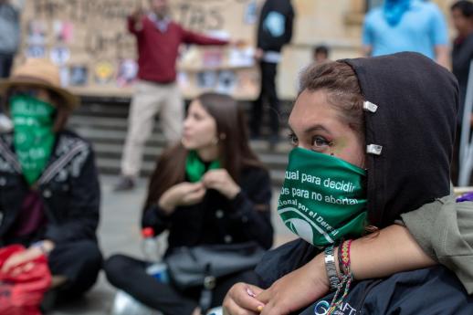 Protesters with green scarves around their faces